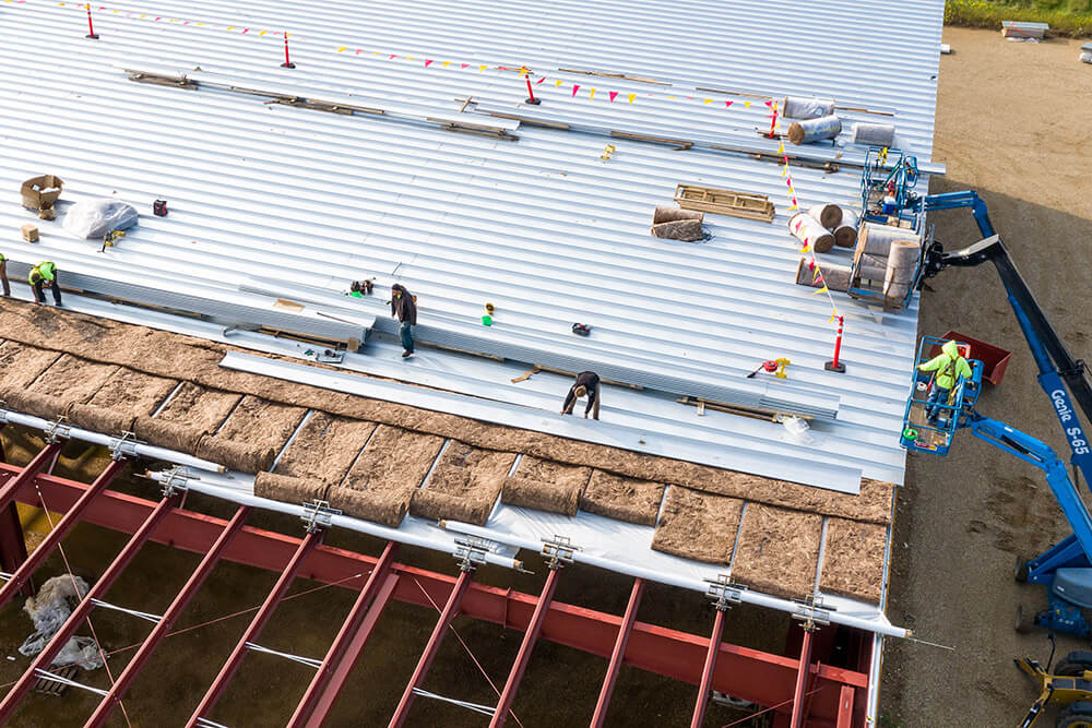 construction workers installing roof panels on a building