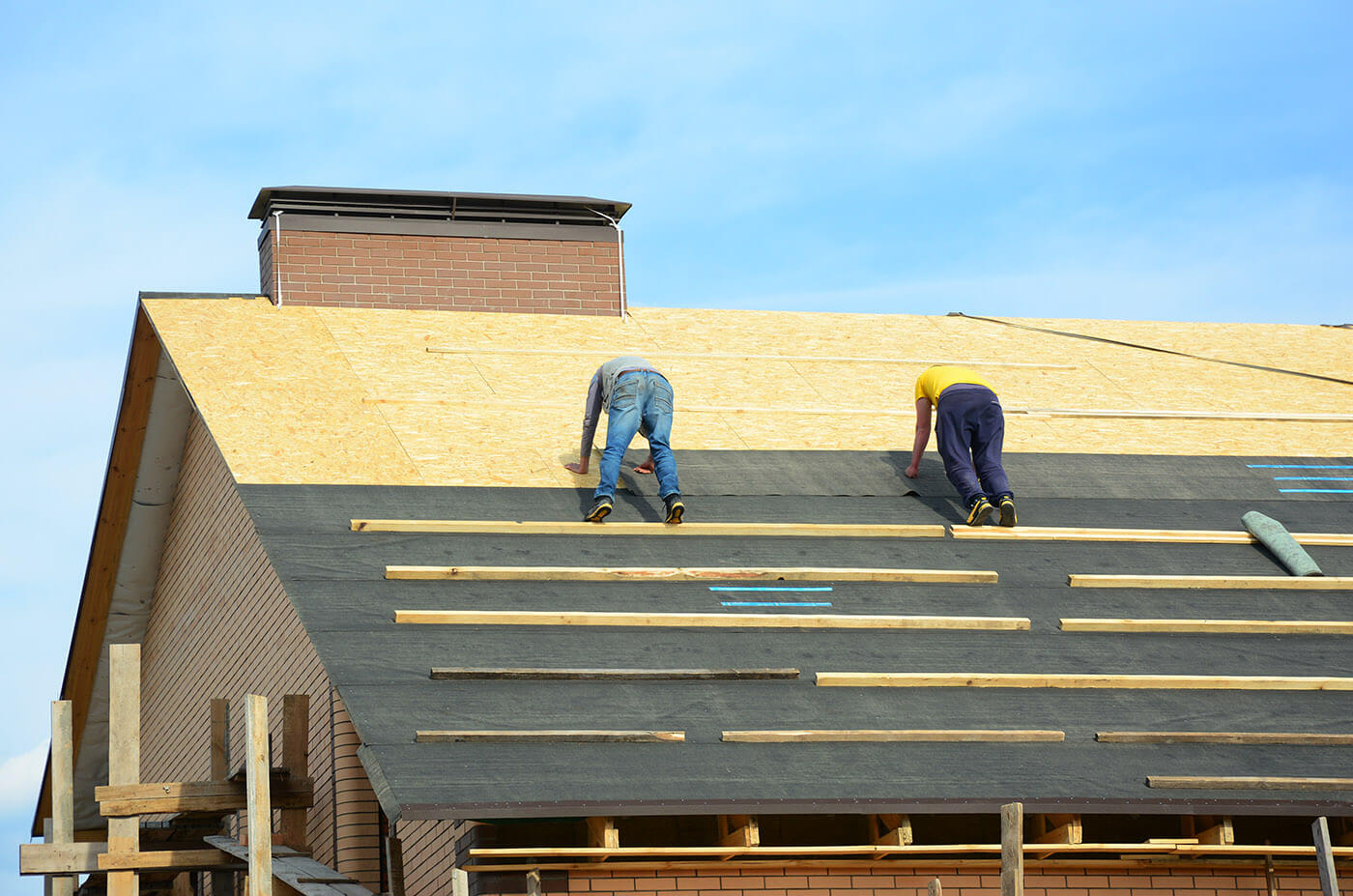 roofing contractors installing a new roof on a house
