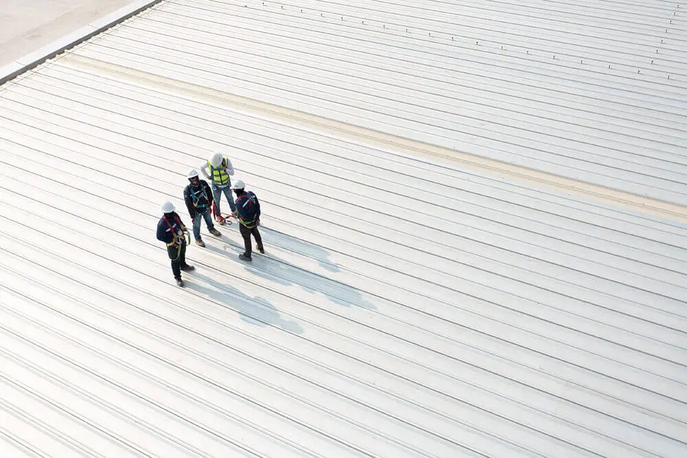 construction workers installing roof panels on a commercial building